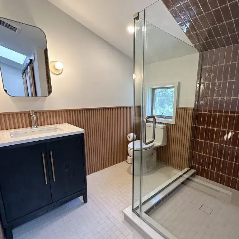 Mid-century bathroom with wood lower-wall paneling in Roscoe, NY by Timber Design + Build